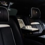 Elegant interior of a black and white Rolls-Royce Cullinan, highlighting premium materials and refined design elements.