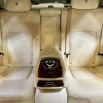 A black Rolls Royce Ghost rental in Houston parked indoors, showcasing its elegant and sophisticated design.