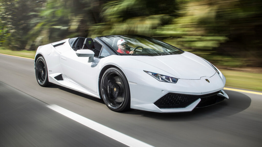 Lamborghini Huracán EVO driving on a scenic road in Houston, TX, showcasing luxury and exotic car rental by Luxe AF Motors.