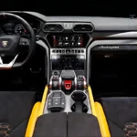Lamborghini Urus interior cockpit driver view with carbon fiber and orange stitching
